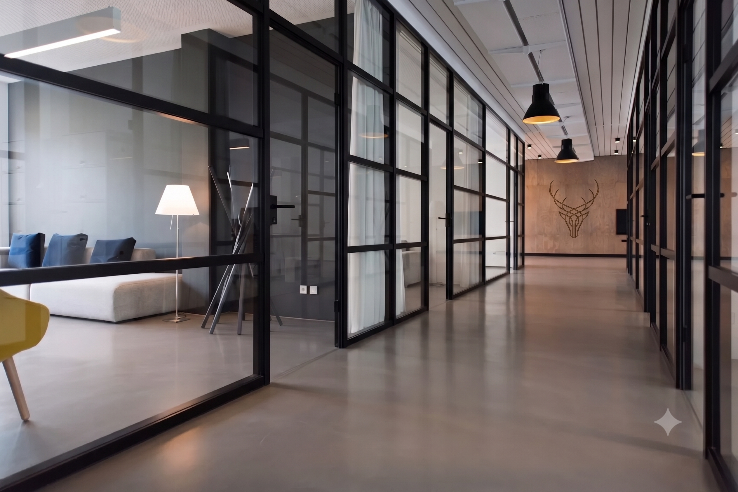 Interior view of Cotswolds Capital's London office, glazed corridor with the firm's stag emblem on the far wall, reflecting an institution defined by its work rather than individual personality